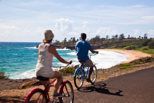 A couple riding beach cruisers on the Kapaʻa coastal path
