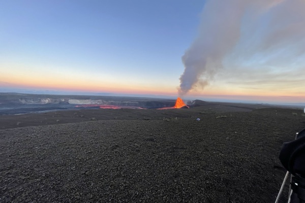 Lava fountain and a plume of steam in Kīlauea's summit crater at dusk
