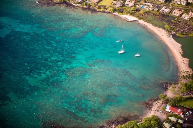 Aerial view of Anaehoʻomalu Bay, its curved beach and the Kuʻualiʻi Fishpond behind it