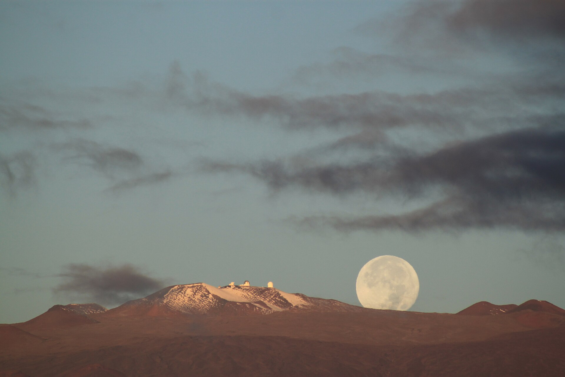 Snow and moonlight on Mauna Kea observatories