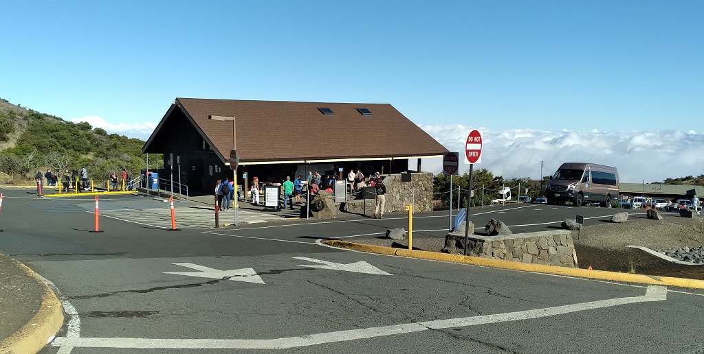 Visitor Information Station with visitors and a sea of clouds below Mauna Kea