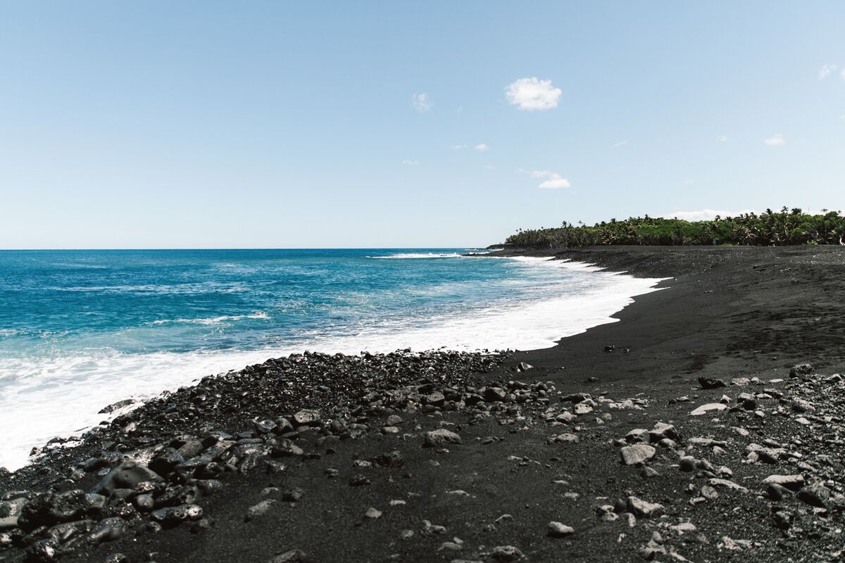 Waves breaking on the black-sand shore of Pohoiki Beach in Puna
