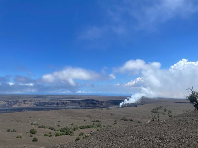 Steam rising from Halemaʻumaʻu crater across the ash-covered floor of Kīlauea caldera
