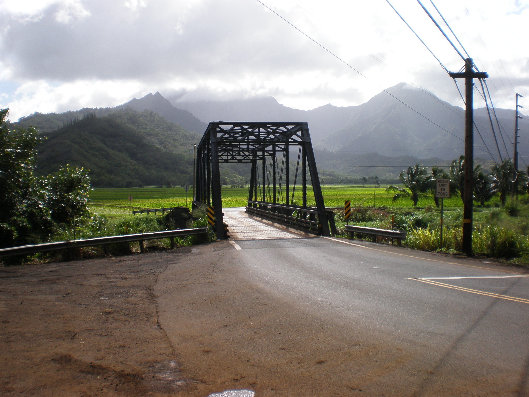 The one-lane steel truss Hanalei Bridge on Highway 560, with taro fields and green mountains beyond