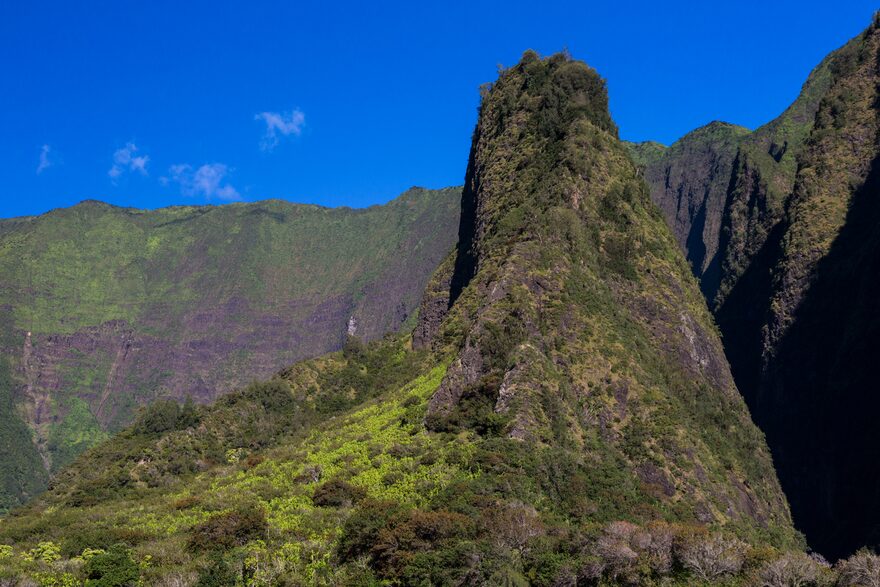 Kūkaʻemoku, the ʻĪao Needle, rising from green valley walls under a deep blue sky