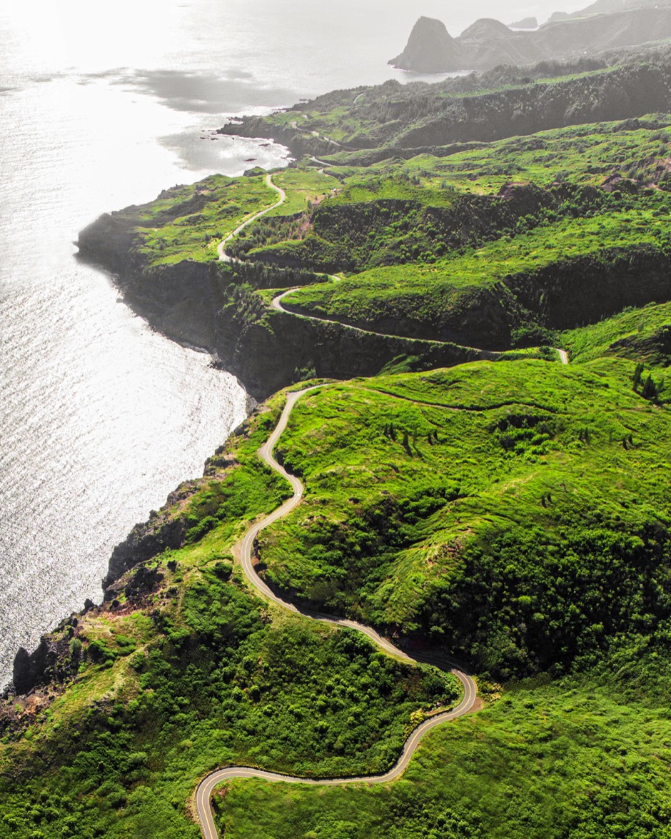 Aerial view of the Road to Hāna winding along a green coastline