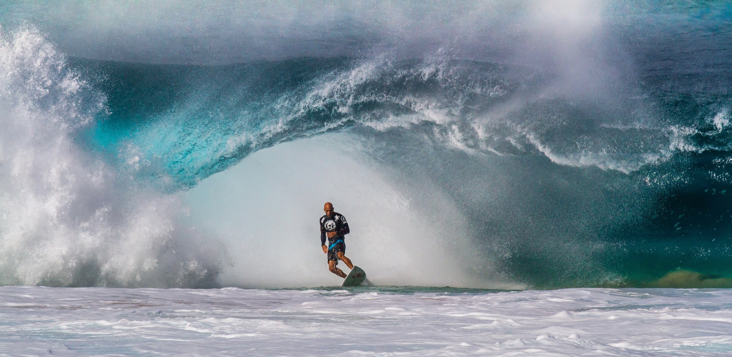 A surfer riding a powerful wave at Banzai Pipeline